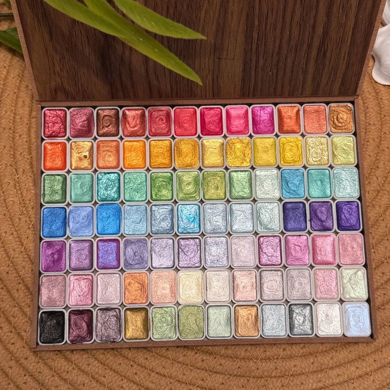 120 glitter watercolor paints in a wooden box, arranged in a grid with vibrant colors and metallic finishes.