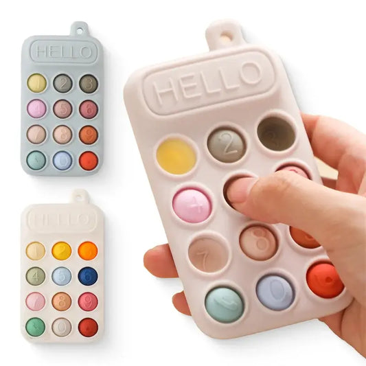 Silicone baby teether toy shaped like a cell phone with colorful buttons and a hand pressing a button.