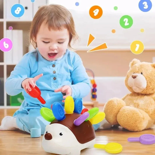 Hedgehog-shaped fine motor toy with brown body and colorful key pieces