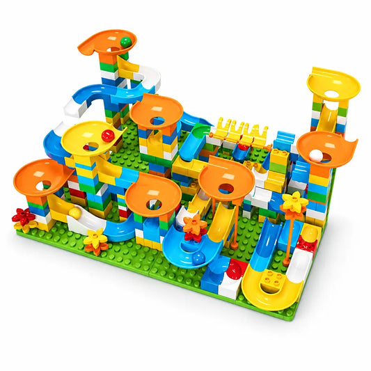 A colorful children's marble run toy set built from interlocking blocks, shown assembled on a green base plate with the words 'Big Size' above it. The structure includes orange loops, blue curved tracks, yellow ramps, white and green blocks, and small decorative star and flower pieces.