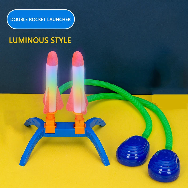 Double rocket launcher with luminous rockets, blue base, and green stomp pump, designed for outdoor play.