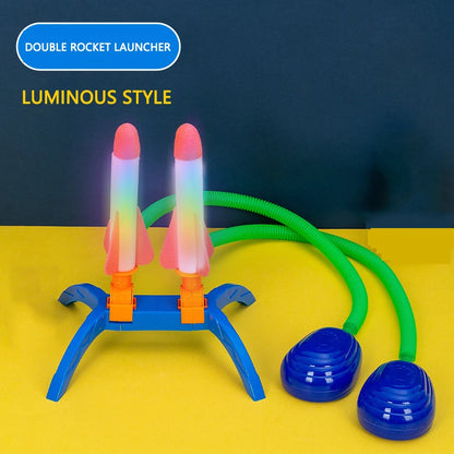 Double rocket launcher with luminous rockets, blue base, and green stomp pump, designed for outdoor play.