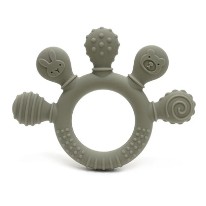 Sage green silicone baby teether with various textured shapes including a bunny, bear, and spiral design.