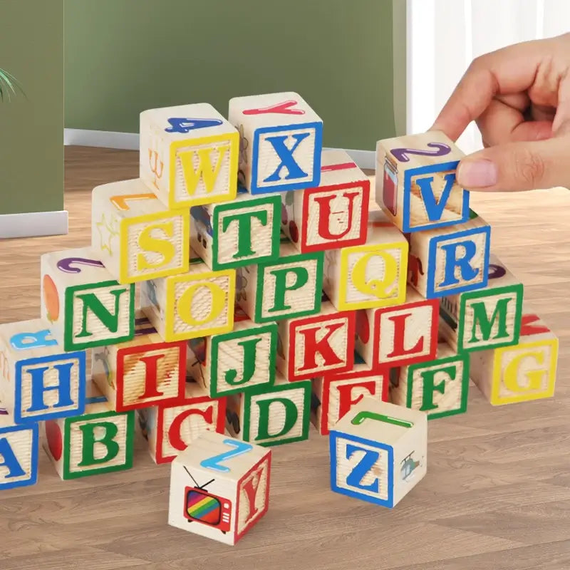Colorful wooden blocks featuring letters and numbers, stacked in a playful arrangement, with a child's hand reaching for a