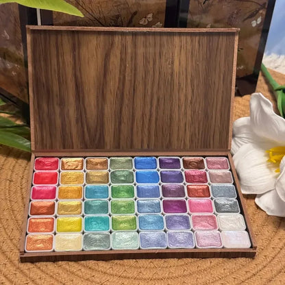 Wooden box containing 48 glitter watercolor paints in various colors, arranged in a neat grid.