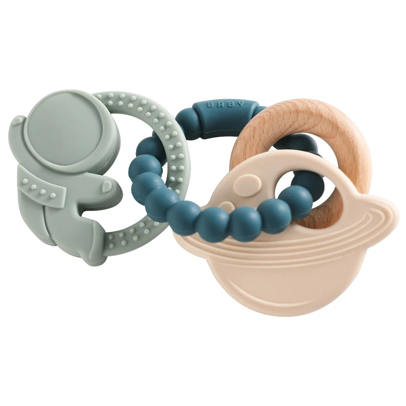 Silicone teether set featuring a planet design, a green figure, and wooden elements, suitable for toddlers.
