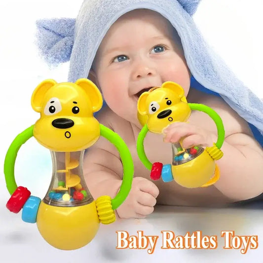 Yellow bear-shaped baby rattle with colorful beads and green handles, with a baby playing in the background.