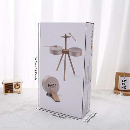 Kids drum set in a box, featuring two drums and a cymbal, with wooden sticks, educational toy for children.