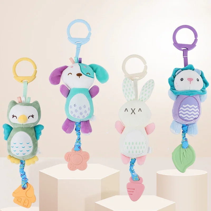 Four colorful soft stuffed animal rattles with hand grips, featuring an owl, a dog, a bunny, and a lion design.