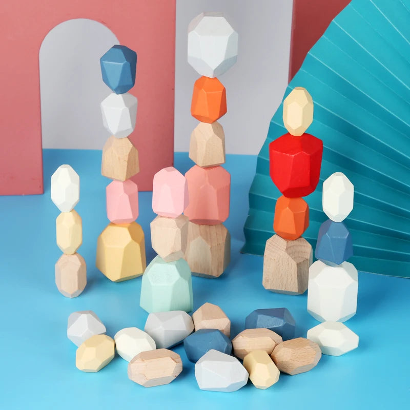 Colorful wooden stacking rocks in various shapes and sizes, arranged with some loose pieces on a blue surface.