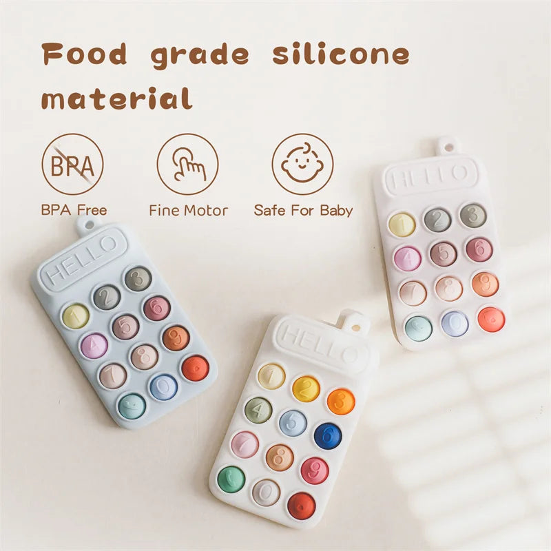 Colorful silicone cell phone teether toy with buttons, featuring text 'HELLO' and various colored circles.