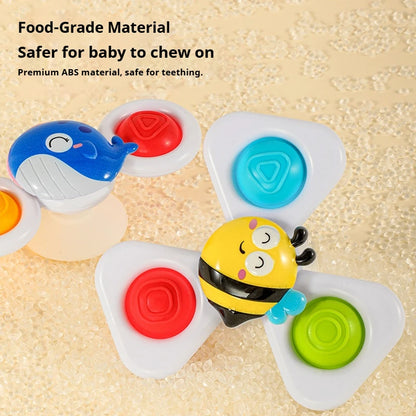 Three colorful suction cup spinning top toys featuring a whale, bee, and triangle shapes with buttons.