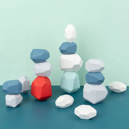 Colorful wooden stacking rocks in various shapes, including red, blue, and white, arranged on a teal surface.