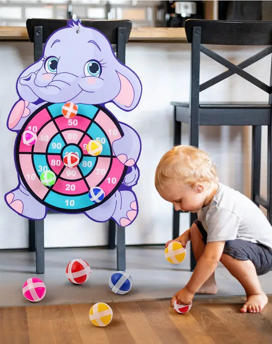 Cartoon elephant dart board with colorful sticky balls, child playing with balls on the floor, interactive toy.