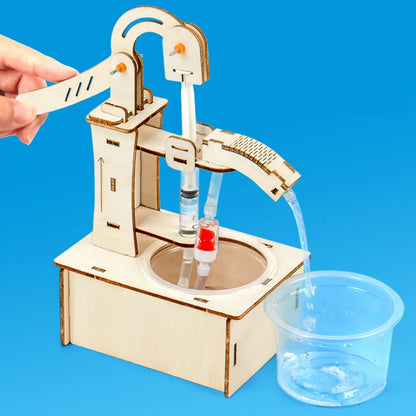 Wooden DIY science toy with water flow mechanism, clear container, and assembly parts on a blue background.