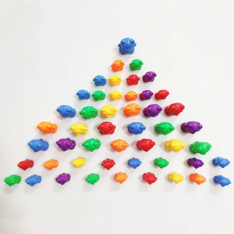 Colorful plastic counting bears in various colors arranged in a triangular pattern on a white background