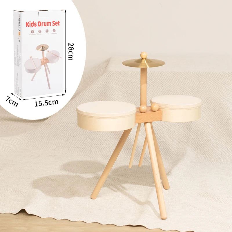 Wooden kids drum set with two white drum pads, a cymbal, and a light wood tripod stand.