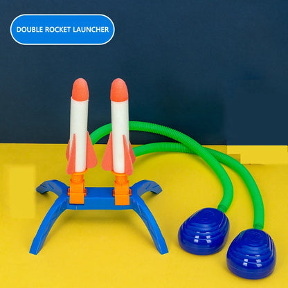 Double rocket launcher with two orange-tipped rockets, blue base, and green stomp pump hoses on a yellow background