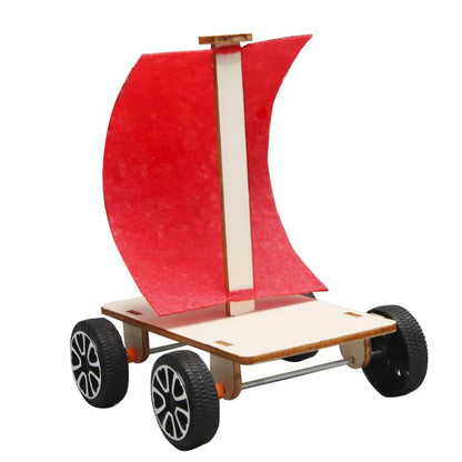 Wind-powered car with a red sail, wooden base, and black wheels, designed for kids' STEM projects.