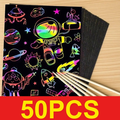 50 colorful scratch-off paper sheets featuring space-themed designs and wooden styluses, on a light wooden surface.