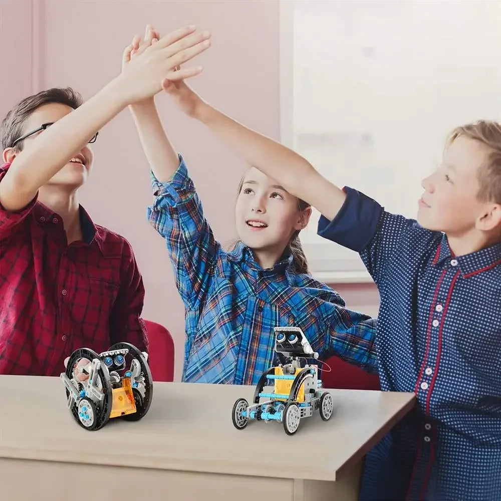 Three children celebrating with their hands raised, two colorful solar-powered robot toys on the table in front of them.