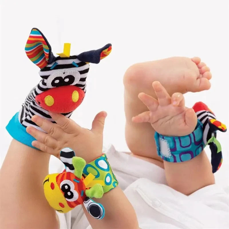 Colorful baby wrist rattles and socks featuring animal designs, on a baby's feet and hands, sensory toys for infants.
