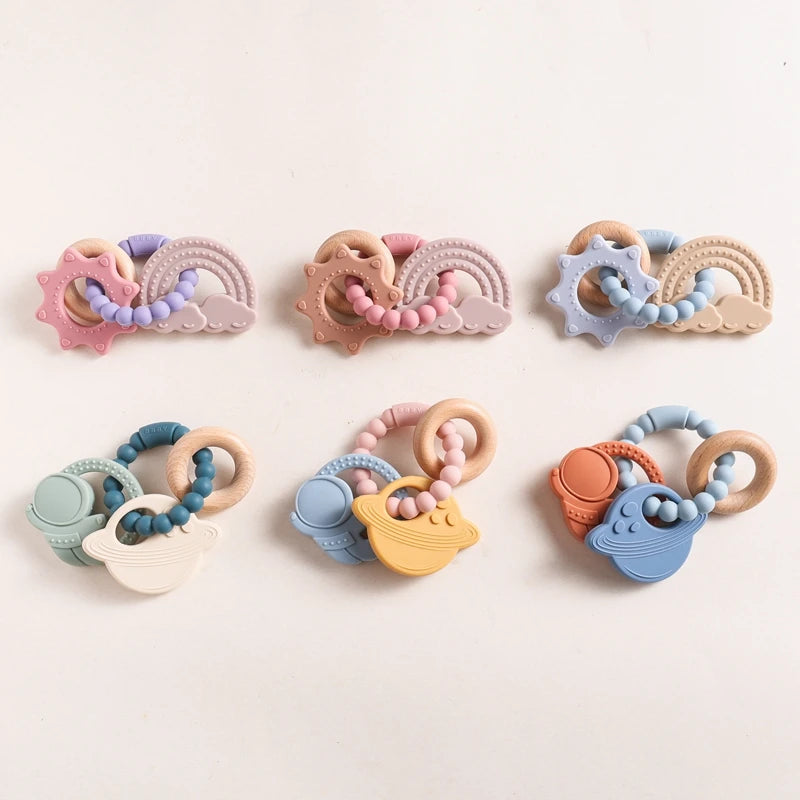Five silicone teething rings in various colors, featuring shapes like waves, suns, and animals with wooden accents.