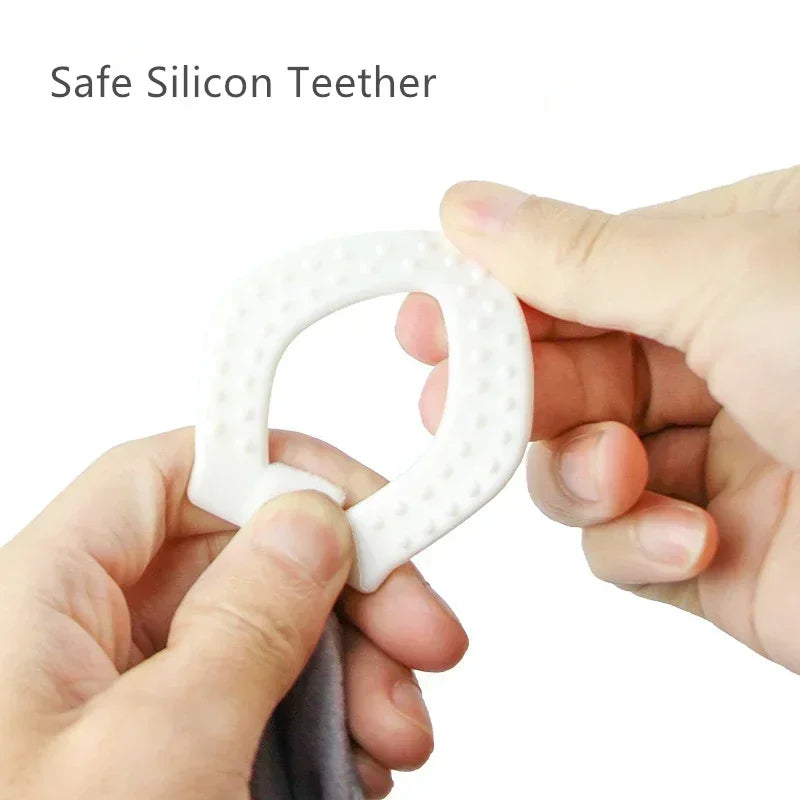 White silicone teether held between two hands, featuring a textured surface for grip and comfort.