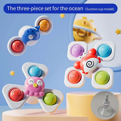 Three colorful suction cup spinning top toys featuring a bird, octopus, and crab design, suitable for kids.