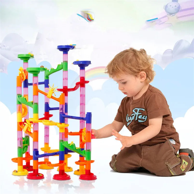 Colorful marble run track with various levels, featuring a child playing with the blocks on the floor.