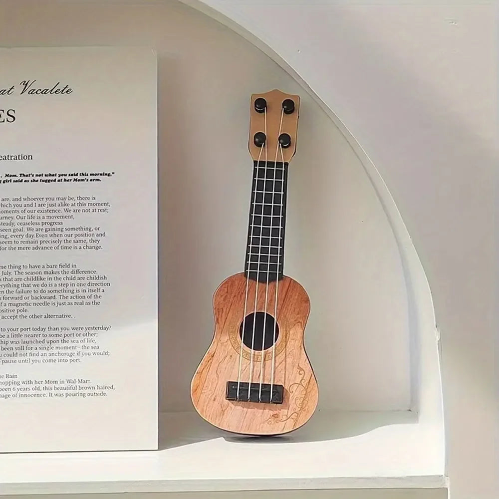Mini classical ukulele guitar toy with a wooden body and black strings, displayed on a white background.