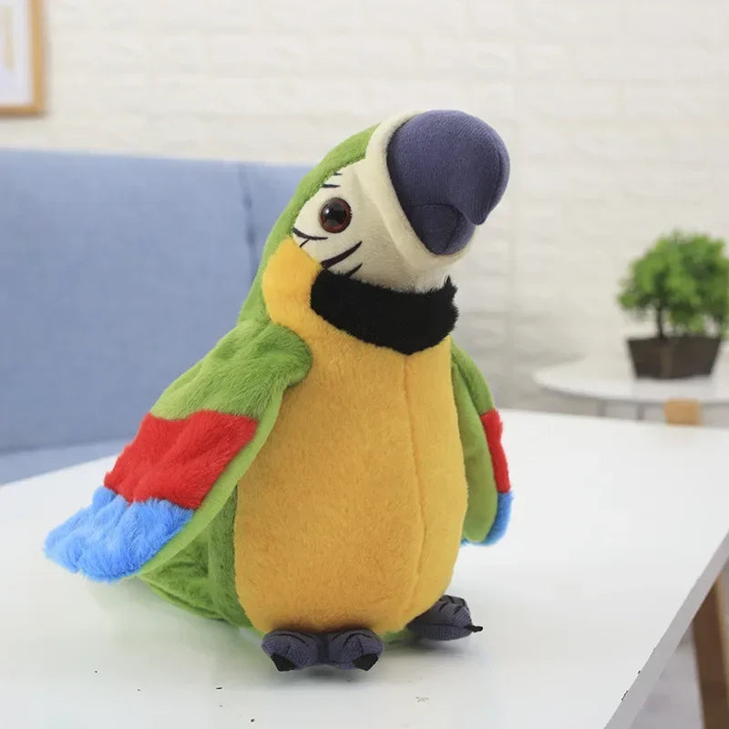 Green stuffed macaw parrot plush toy with colorful wings, smiling face, and black beak, sitting on a table.