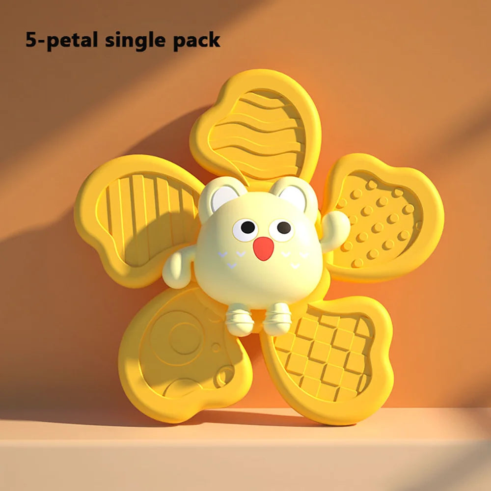 Colorful yellow baby bath toy shaped like a flower with various textured petals, featuring a cute owl face in the center.