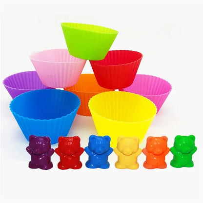 Colorful plastic counting bears in red, orange, yellow, green, blue, purple lined up in front of vibrant silicone cups.