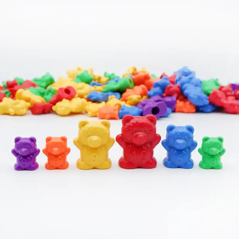Colorful plastic counting bears in various sizes and colors, surrounded by smaller bear figures, educational toy.