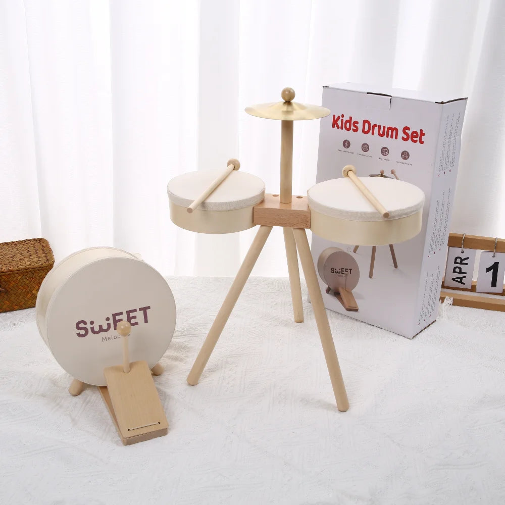 Kids drum set with two white drums, wooden stand, and a cymbal, featuring a light wood finish.