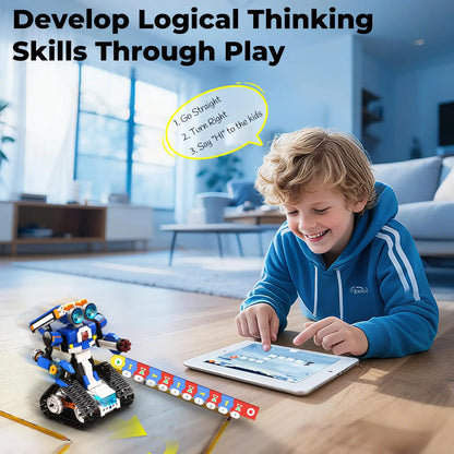 A boy playing with a remote control robot toy on the floor, using a tablet. The robot is colorful with wheels.