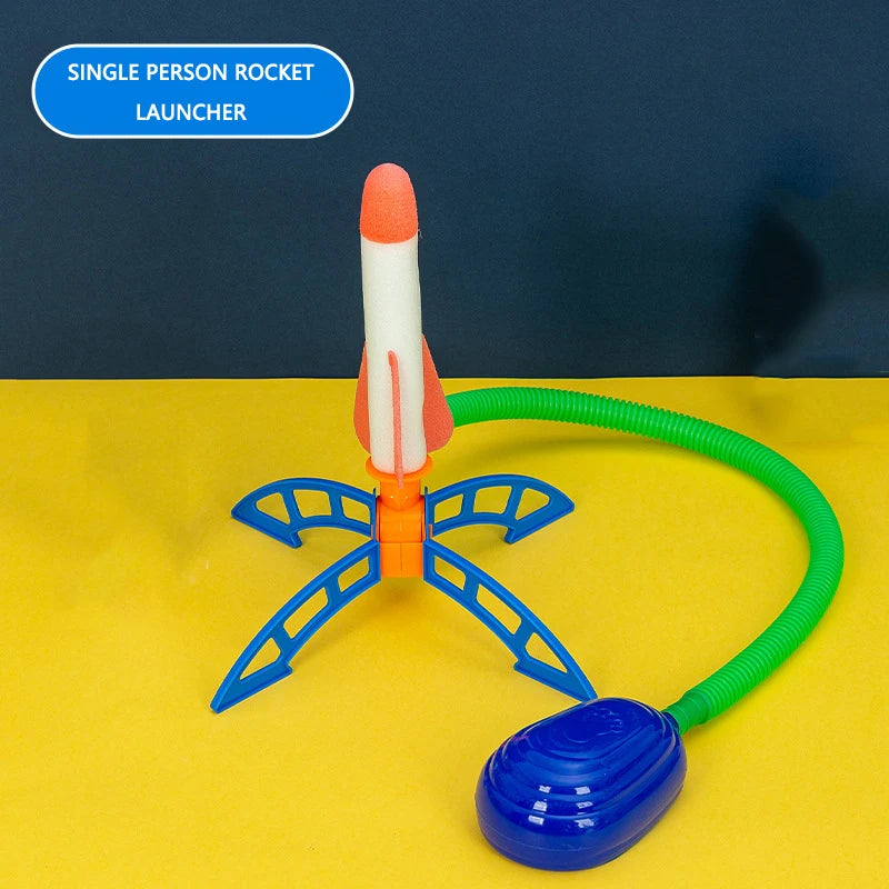 Colorful rocket launcher with orange and white rocket, green hose, and blue base, designed for outdoor play.
