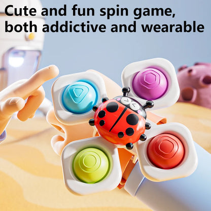 Three colorful suction cup spinning top toys featuring a ladybug design, held in a child's hand.